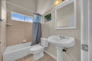 Bathroom featuring tile patterned floors and shower / bathtub combination with curtain