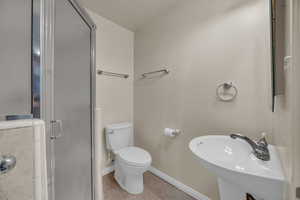 Bathroom with a shower stall and tile patterned flooring