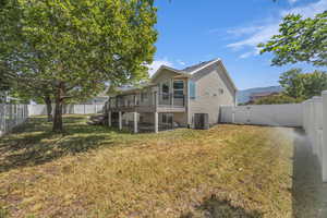Rear view of house with stairs, a fenced backyard, and a wooden deck