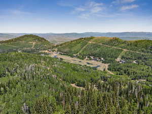 View of mountain backdrop featuring a heavily wooded area
