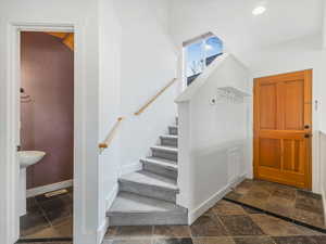 Foyer entrance with stone tile floors and staircase