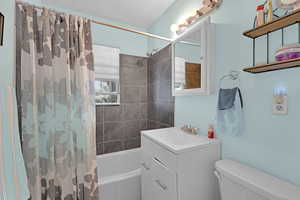 Bathroom featuring shower / bathtub combination with curtain and vanity