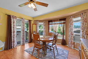 Dining area with light wood-type flooring, plenty of natural light, ceiling fan, and cooling unit