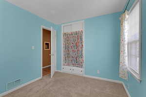 Unfurnished bedroom with carpet and a closet