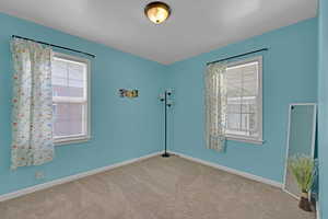 Empty room featuring carpet floors and baseboards