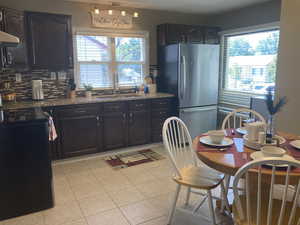 Kitchen featuring freestanding refrigerator, black range with electric stovetop, healthy amount of natural light, and decorative backsplash