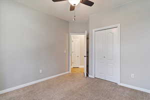 Unfurnished bedroom with light carpet, a closet, and ceiling fan