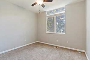 Empty room with carpet flooring and ceiling fan