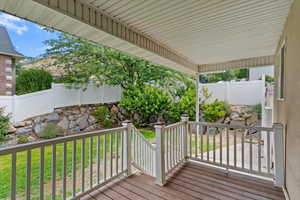 Wooden terrace with a fenced backyard