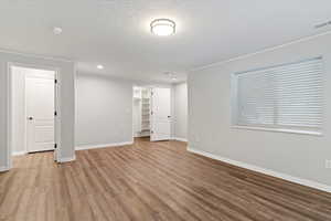 Spare room with wood finished floors, a textured ceiling, a smoke detector, and recessed lighting