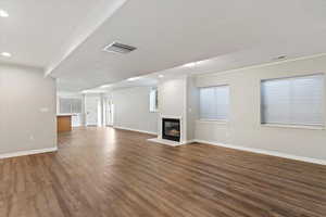 Unfurnished living room featuring recessed lighting, wood finished floors, and a fireplace with flush hearth