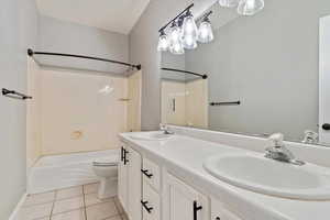 Bathroom with shower / tub combination, tile patterned flooring, and double vanity