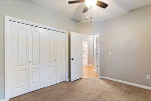 Unfurnished bedroom with light carpet, a closet, and ceiling fan