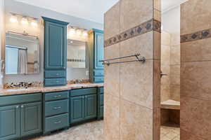 Bathroom featuring double vanity and a tile shower
