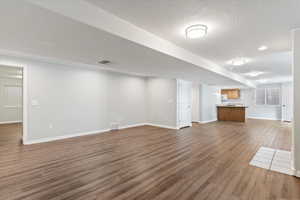 Unfurnished living room with dark wood finished floors and a textured ceiling