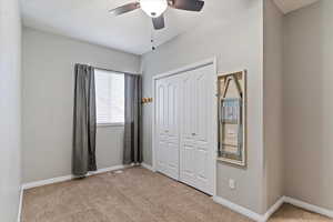 Unfurnished bedroom with carpet floors, a closet, and ceiling fan