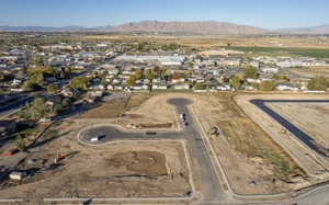 Aerial overview of property's location with a mountainous background and nearby suburban area