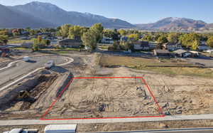 Aerial perspective of suburban area featuring property parcel outlined and a mountain backdrop