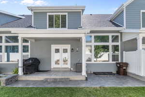 Back of house with a shingled roof and stucco siding