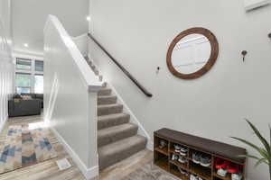 Stairway featuring wood finished floors and recessed lighting