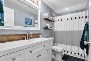 Full bath featuring vanity, a textured ceiling, and a shower with curtain