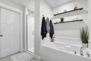 Full bath featuring a shower stall and a garden tub