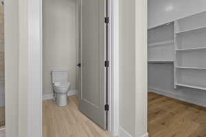 Full bathroom with toilet and wood finished floors