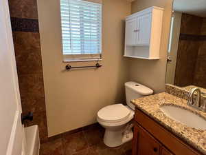 Full bathroom featuring vanity, a textured ceiling, and tub / shower combination