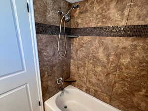 Bathroom featuring a textured ceiling and bathing tub / shower combination