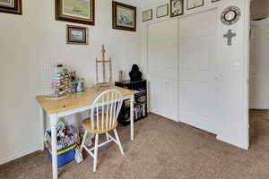 Carpeted home office featuring baseboards