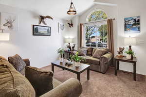 Living room with carpet and lofted ceiling