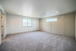 Spare room with healthy amount of natural light, light colored carpet, and recessed lighting