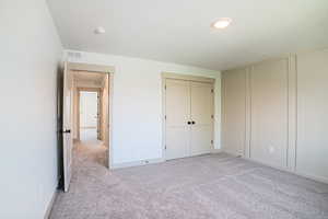 Unfurnished bedroom with light colored carpet