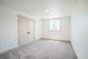 Unfurnished bedroom with carpet flooring and baseboards