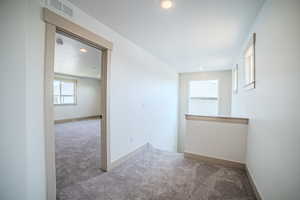 Carpeted empty room with recessed lighting and baseboards