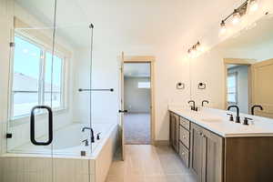 Full bath featuring a bath, double vanity, tile patterned flooring, and plenty of natural light
