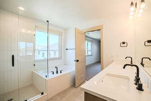 Full bathroom with double vanity, tile patterned flooring, a garden tub, and a stall shower