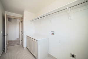 Laundry area featuring electric dryer hookup, washer hookup, and light colored carpet