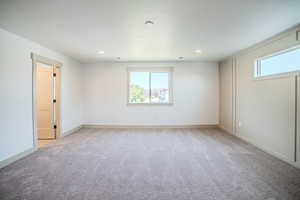 Spare room featuring light colored carpet and recessed lighting