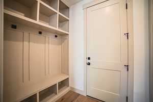Mudroom with light wood-type flooring and baseboards