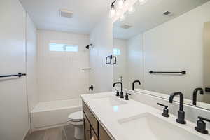 Bathroom featuring double vanity, tile patterned flooring, and shower / bathtub combination