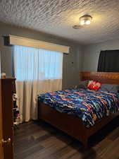 Bedroom featuring a textured ceiling and wood finished floors