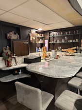 Bar area with dark wood-style flooring and a drop ceiling