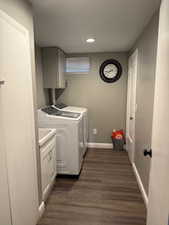 Laundry room with washer and dryer, cabinet space, dark wood-style flooring, and recessed lighting