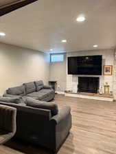 Living area featuring a large fireplace, wood finished floors, and recessed lighting