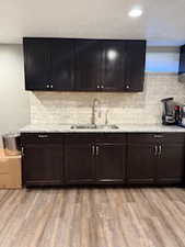 Bar area with light wood-style flooring and tasteful backsplash