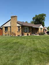 Rear view of house with a lawn and a chimney