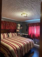 Bedroom featuring wood finished floors and a textured ceiling