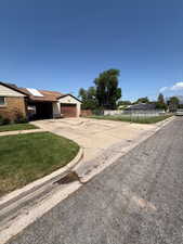 View of front facade with concrete driveway, a front lawn, and a garage