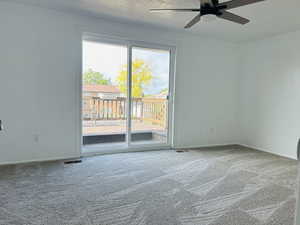 Empty room with carpet and a ceiling fan